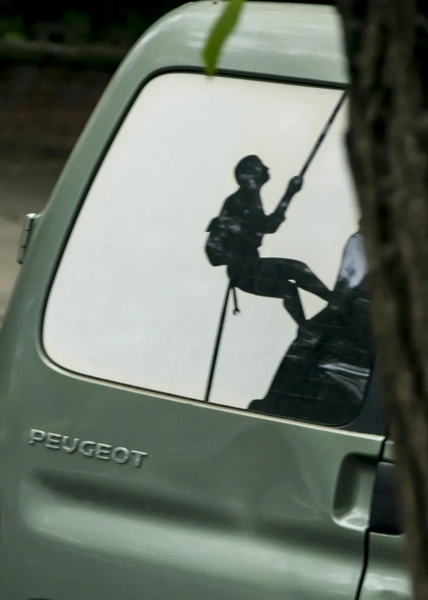 Silhouette decal of a climber rappelling on a Peugeot van window